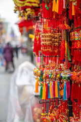 Chinatown colorful souvenir shop street display with defocused pedestrians copy space.