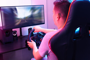 A man is playing a video game with a steering wheel