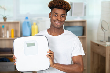 young man showing weight machine