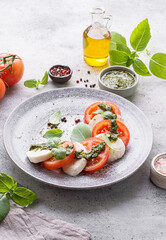 tomatoes with mozzarella with basil and pesto sauce