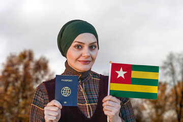 Muslim Woman Holding Passport and Flag of Togo	
