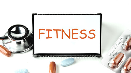 Fitness, healthy lifestyle and sport concept: FITNESS written on a white business card on a stand...