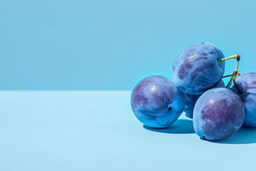 close up of blue plum fruits over blue background with copy space