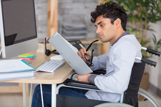 businessman sitting at desk in wheelchair