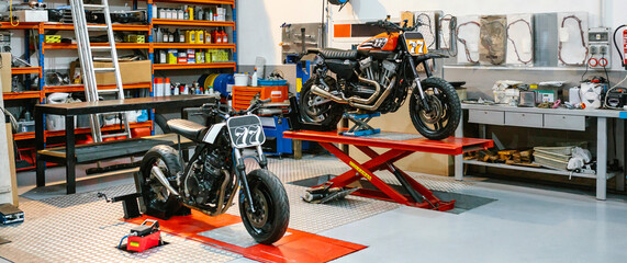 Banner of empty motorcycle workshop with custom motorbikes over platforms ready to repair. Two...