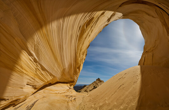 A sand dune and massive alcove carved into a cliff in the Utah d