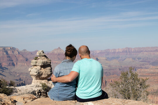 ouple sitting together at Grand Canyon edge