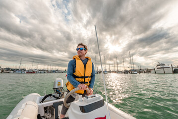 Active middle age man driving boat