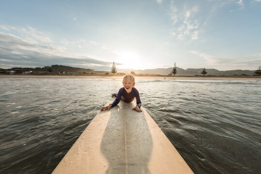 Happy child on surfboard in ocean