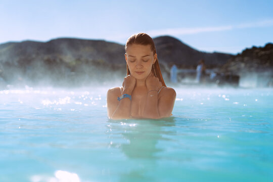 Woman relaxing in hot spring Blue Lagoon, Iceland.