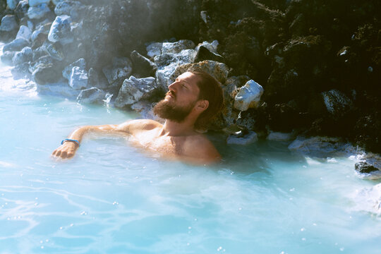 Man relaxing in hot spring Blue Lagoon, Iceland.