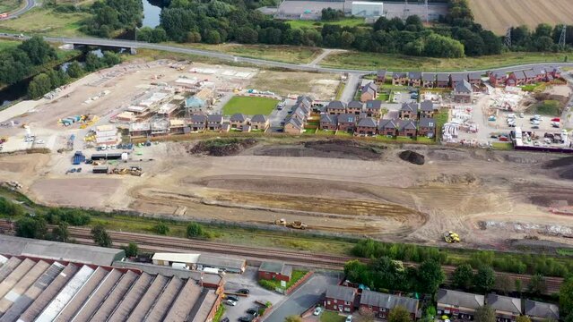 Aerial drone footage of a new housing development being made in the town of Wakefield West Yorkshire in the UK showing a tractor flattening grounds for the houses foundations