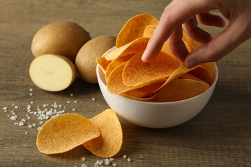 Potato chips in a bowl on a wooden background