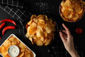 Potato chips in bowls with sauce on a dark background