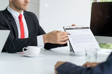 Dealer agent explaining contract information to client in meeting room.