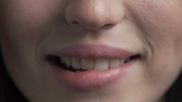beautiful woman passionately bit her lip, white teeth. close-up of Caucasian girl's mouth