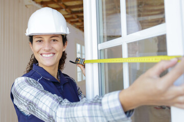 happy beautiful woman builder with tape measure