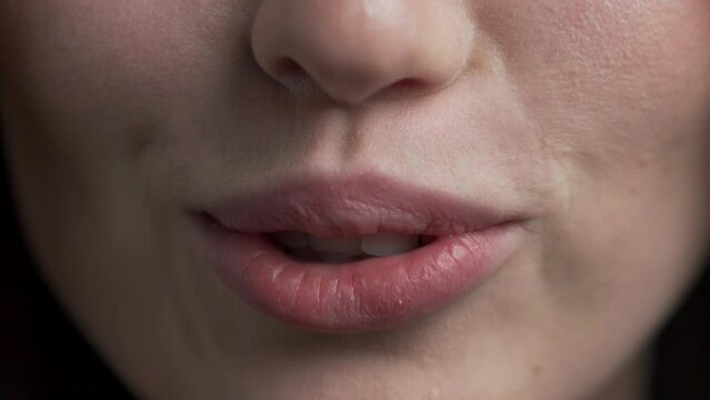 Cropped view lower part of pretty young woman face speaking talking before camera showing white straight healthy teeth. of beautiful female lips smiling and moving when lady is making speech