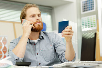 man holding color charts on telephone