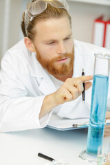 leasant male biologist holding a test tube in a lab