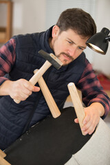 handsome man repairing chair at home