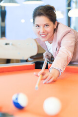 young beautiful smiling woman playing pool
