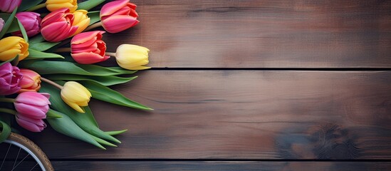 A copy space image featuring vibrant tulip flowers frames and an old bike placed on a rustic wooden background 117 characters