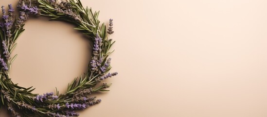 A wedding wreath made of rosemary and lavender leaves displayed on a textured beige background with copy space image