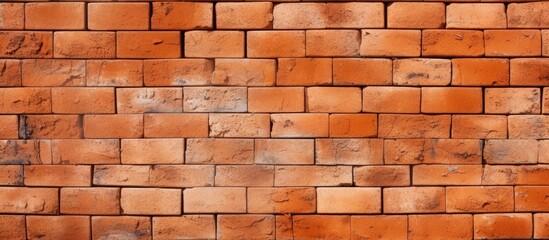 Obraz premium An expansive orange brick wall with an abstract pattern serves as a textured background with copy space for design purposes