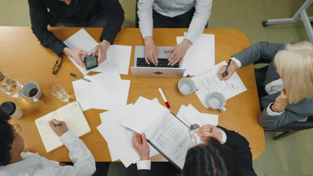 Top view of company reporting meeting. Professional financial analysts business people team gathered for quarterly calculation of company's funds, analyze accounts. Command analysis, teamwork concept.