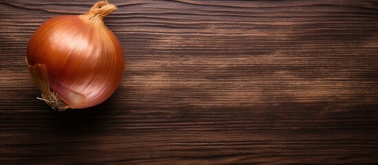 A top down view of a Crimean sweet onion placed on an aged wooden surface creating an appealing copy space image