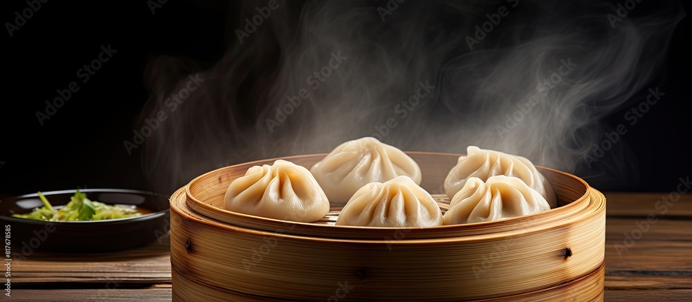 Poster copy space image of chinese steamed dumpling and steamed pork bun served in a bamboo steamer on a wo