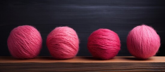 An old wooden surface displays three pink balls of wool in this copy space image