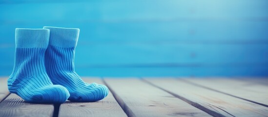 A copy space image of blue socks resting on a surface made of white wood