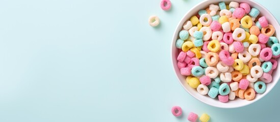 An aerial perspective of a bowl filled with cereal rings and marshmallows creating an appealing copy space image