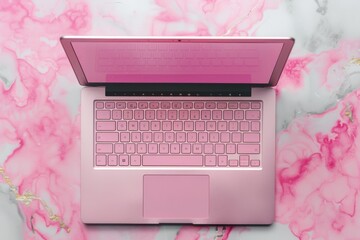 A pink laptop with a visible keyboard placed on a sleek marble surface in a minimalist setting