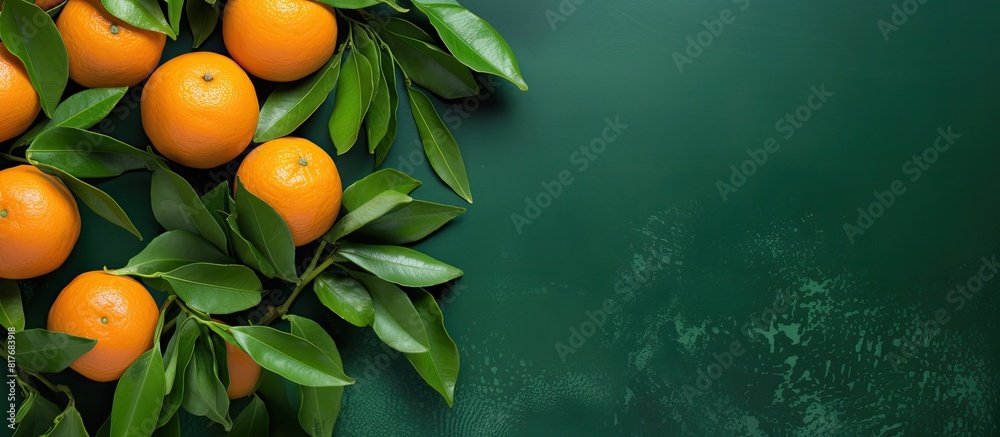 Poster top view of fresh ripe mandarins with green leaves on a colored background providing ample copy spac