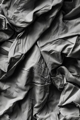 An abstract image of crumpled fabric, with folds and creases creating interesting textures and shadows.