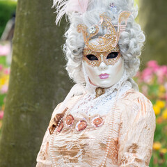 A woman Venetian carnaval character in a park