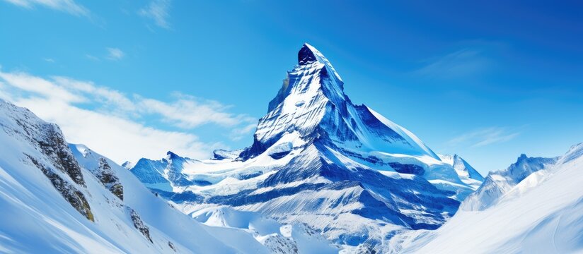 Copy space image of a majestic mountain peak adorned with winter snow set against a backdrop of clear blue skies 108 characters