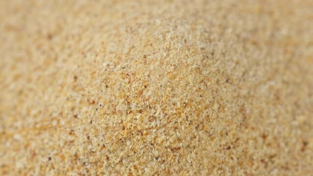 Granulated garlic falling down on heap, top view