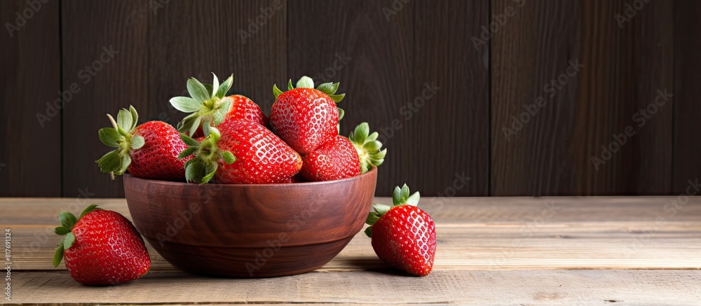 Poster A mouthwatering strawberry sits in a bowl against a rustic wooden background leaving ample blank space for a stunning copy space image