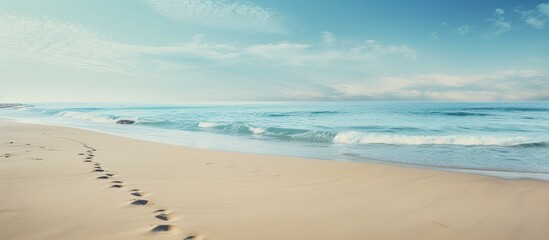 Bare footprints on the Baltic coast captured in a copy space image reveal a serene stretch of gray sea sand along the coastline