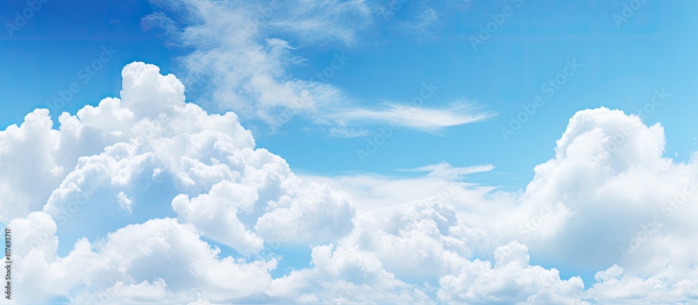 Poster copy space image featuring a serene blue sky adorned with fluffy white clouds
