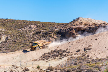 Exclusive large tonnage dumper truck for works going down a slope with a load of earth. Earthworks. © M. Perfectti