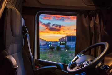 View from the inside of a truck parked in an industrial park of the seat, the steering wheel and...