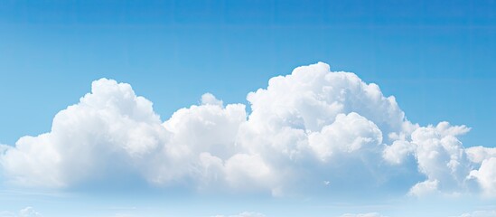 A stunning white cloud floats against a backdrop of a vibrant blue sky creating a mesmerizing copy space image