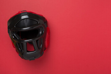 Black leather boxing helmet on color background, top view.