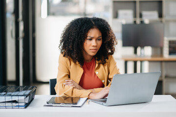 Young woman work late from home in room at late night overtime.Businesswoman bending over workplace...