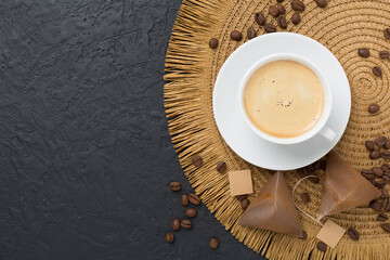 Cup of coffee made using pyramid on concrete background, top view